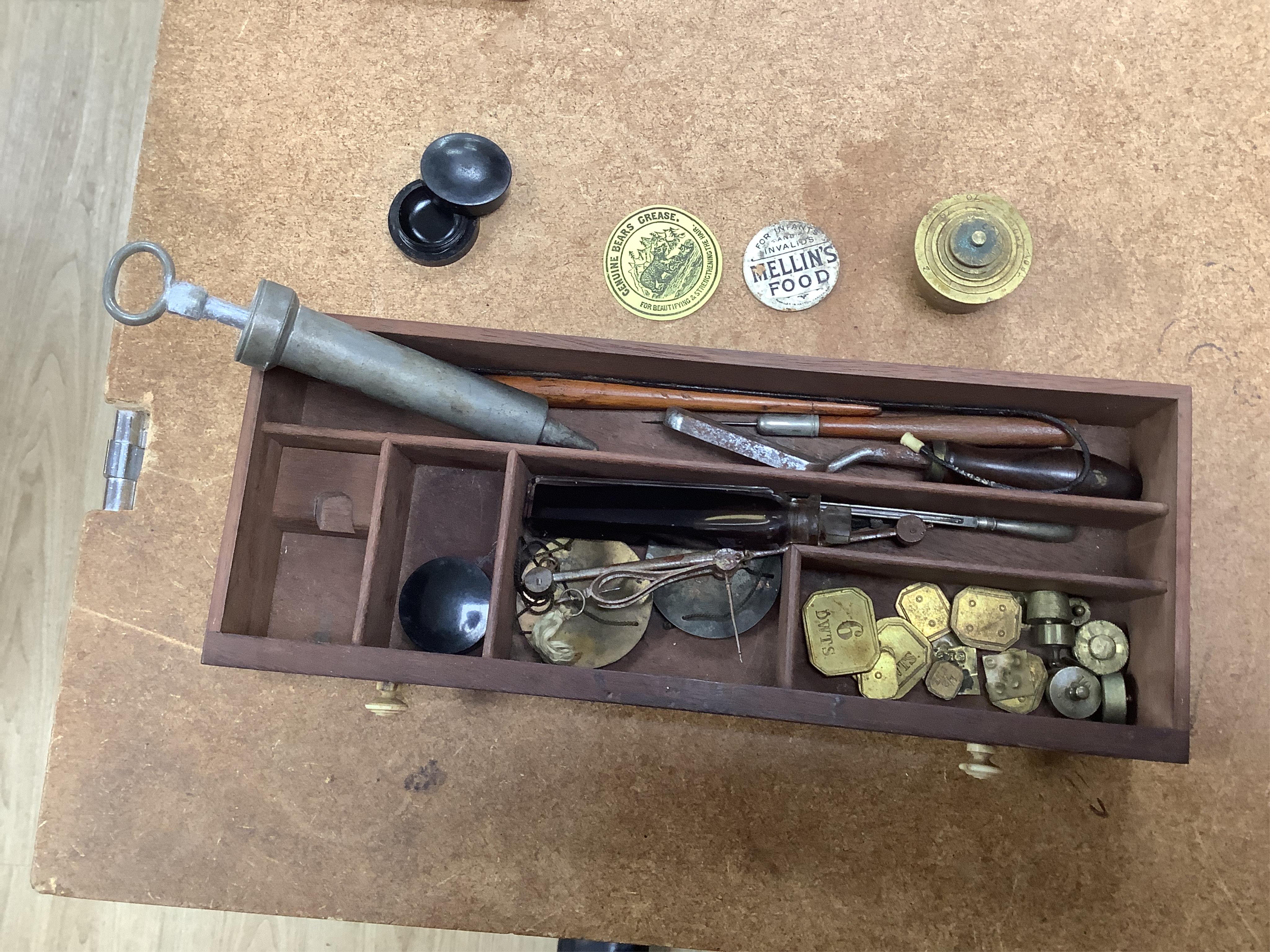 A 19th century mahogany apothecary cabinet, interior with fitting compartments containing twenty-one glass bottles, most with stoppers, five drawers with ivory knobs containing a miniature pestle and water, mixing glasse